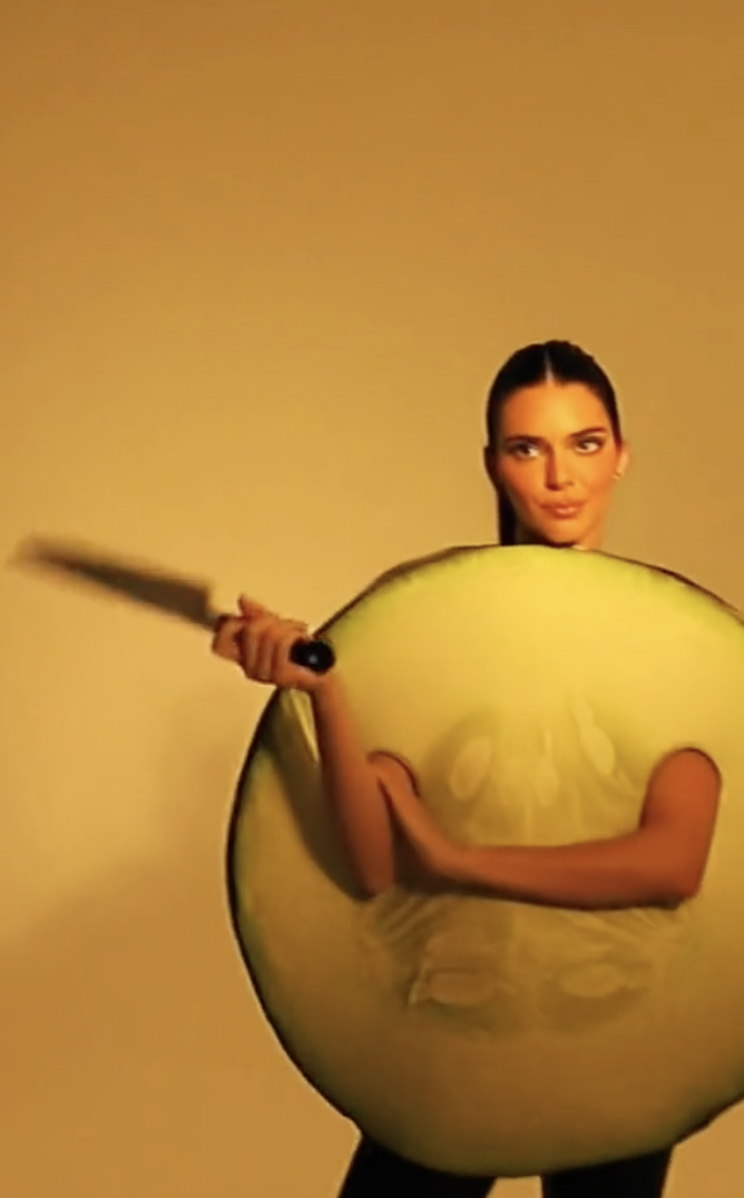 wearing a cucumber suit and holding a knife