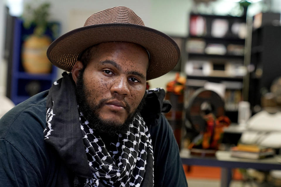 Owner Ali Nervis sits in his bookstore Friday, Aug. 21, 2020 in Phoenix. Black-owned bookstores across the U.S. have seen increased sales following the police killings of Breonna Taylor and George Floyd, and store owners are now asking people who have read about Black history and culture to take action against the systems that have enabled racism. (AP Photo/Matt York)
