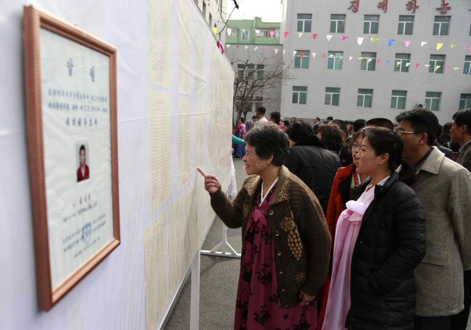 People inspect the list of voters as portrait of a candidate for the national legislature is displayed on the left, during the election at a polling station in Pyongyang, North Korea, Sunday, March 10, 2019. Millions of North Korean voters, including leader Kim Jong Un, are going to the polls to elect roughly 700 members to the national legislature. In typical North Korean style, voters are presented with just one state-sanctioned candidate per district and they cast ballots to show their approval or, very rarely, disapproval. (AP Photo/Dita Alangkara)