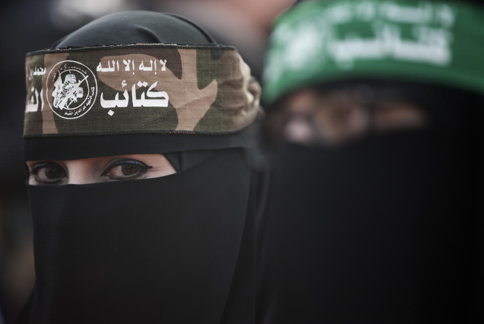A Palestinian woman wears a headband with Arabic that reads: "No God but Allah and Muhammed is his messenger, al-Qassam Brigades" during a mass rally marking the 31st anniversary of the founding of Hamas, an Islamic political party, which has an armed wing of the same name, that currently rules in Gaza, Sunday, Dec. 16, 2018, in Gaza city. (AP Photo/Khalil Hamra)