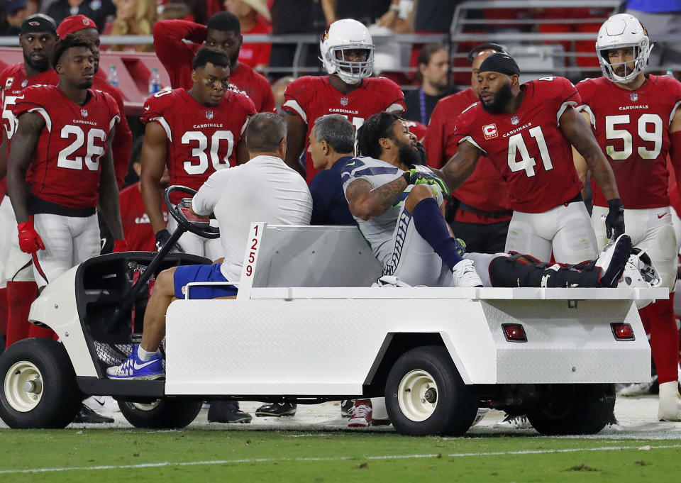 Seattle Seahawks defensive back Earl Thomas (29) is greeted by Arizona Cardinals players as he leaves the field after breaking his leg during the second half of an NFL football game, Sunday, Sept. 30, 2018, in Glendale, Ariz. The Seahawks won 20-17. (AP Photo/Rick Scuteri)