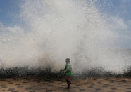 <p>A young girl gets drenched by a large wave during high tide at a seafront in Mumbai, India, on May 24, 2016. (Danish Siddiqui/Reuters) </p>