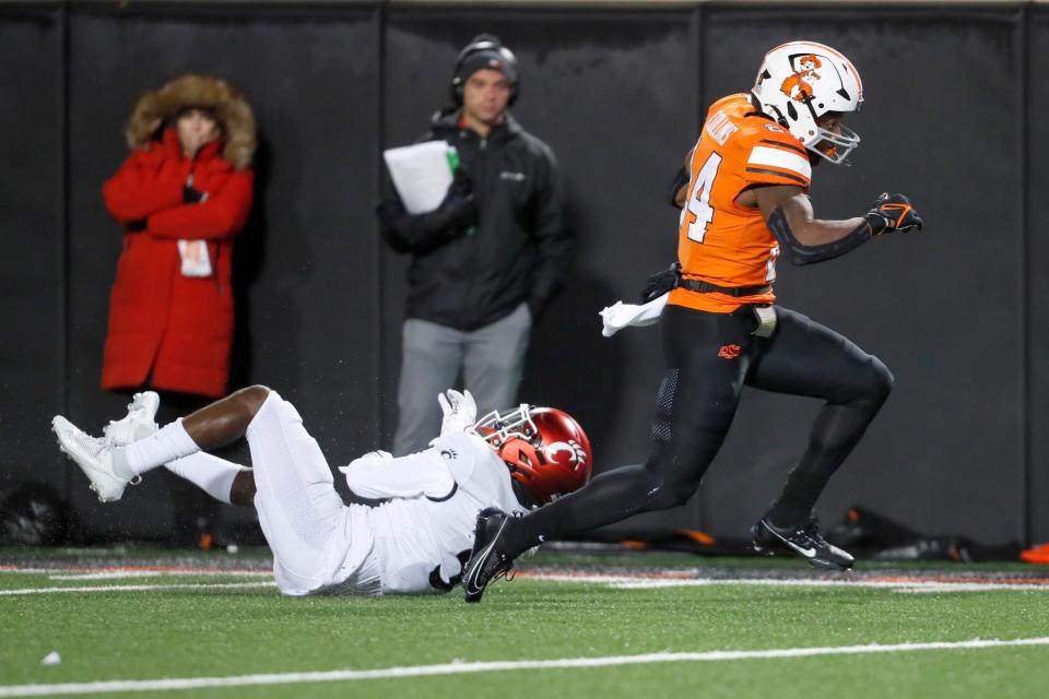 Oct 28, 2023; Stillwater, Oklahoma, USA; Oklahoma State Cowboys running back Elijah Collins (24) runs past Cincinnati Bearcats safety D.J. Taylor (5) for a touchdown during a college football game between Oklahoma State and Cincinnati at Boone Pickens Stadium. Oklahoma State won 45-13. Mandatory Credit: Bryan Terry-USA TODAY Sports