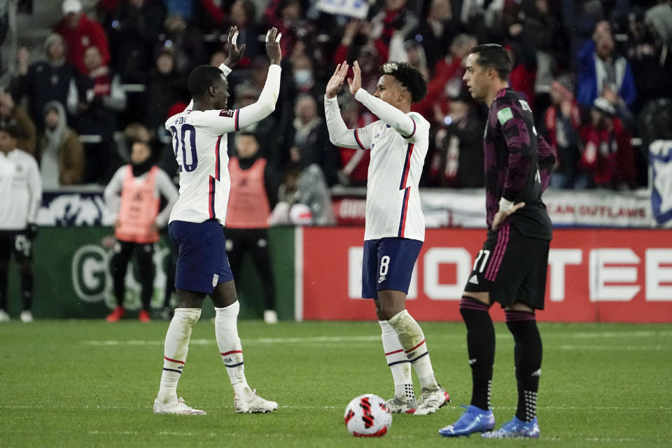 U.S. midfielder Weston McKennie, center, celebrates with teammate Tim Weah (20) after scoring a goal during the second half of the team's FIFA World Cup qualifying soccer match against Mexico, Friday, Nov. 12, 2021, in Cincinnati. (AP Photo/Jeff Dean)