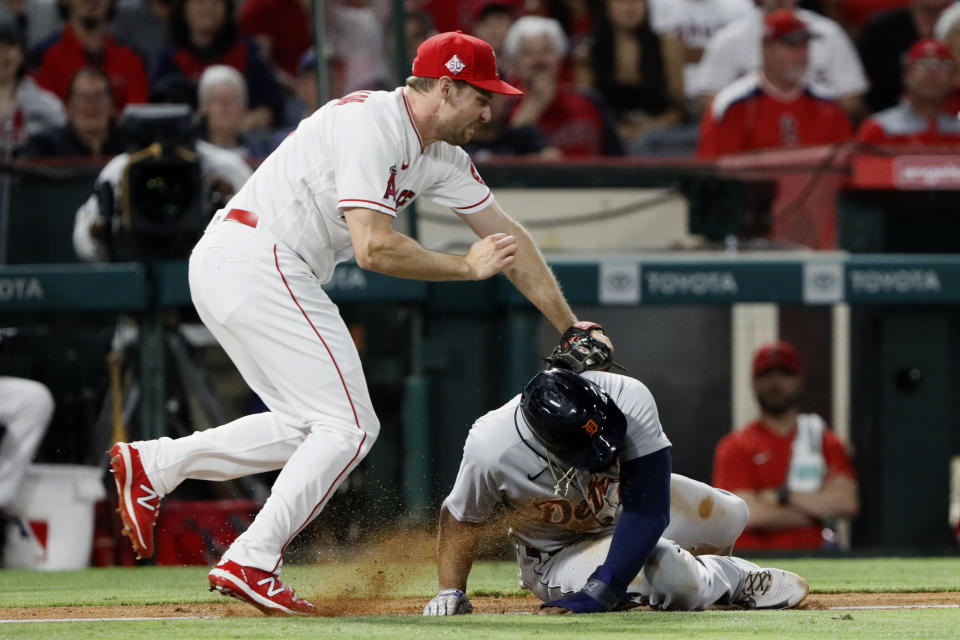 Los Angeles Angels third baseman Phil Gosselin, left, tags out Detroit Tigers' Niko Goodrum in a rundown between third base and home during the seventh inning of a baseball game in Anaheim, Calif., Thursday, June 17, 2021. (AP Photo/Alex Gallardo)