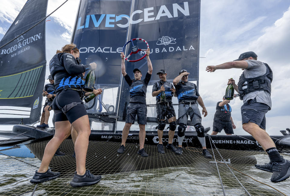 In this photo provided by SailGP, Peter Burling, Co-CEO and driver of New Zealand SailGP Team, lifts the trophy as the team celebrate aboard their F50 catamaran after winning the Mubadala New York Sail Grand Prix in New York, Sunday, June 23, 2024. (Ricardo Pinto/SailGP via AP)