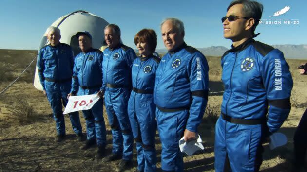 New Shepard crew members line up for pictures after the landing. From left: George Nield, Jim Kitchen, Marty Allen, Sharon Hagle, Marc Hagle and Gary Lai. (Blue Origin via YouTube)