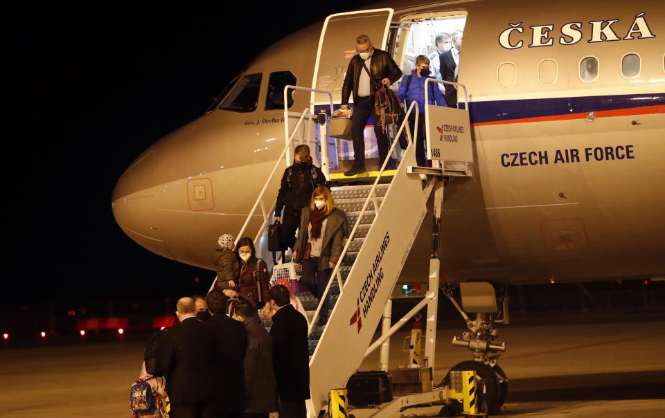 Czech diplomats and their families arrive at the Vaclav Havel airport in Prague, Czech Republic, Monday, April 19, 2021. Russia has ordered 20 Czech diplomats to leave the country within a day in response to Prague's expulsion of 18 Russian diplomats. The Czech government has alleged the Russian Embassy staffers were spies for a military intelligence agency that was involved in a fatal ammunition depot explosion in 2014. (AP Photo/Petr David Josek)