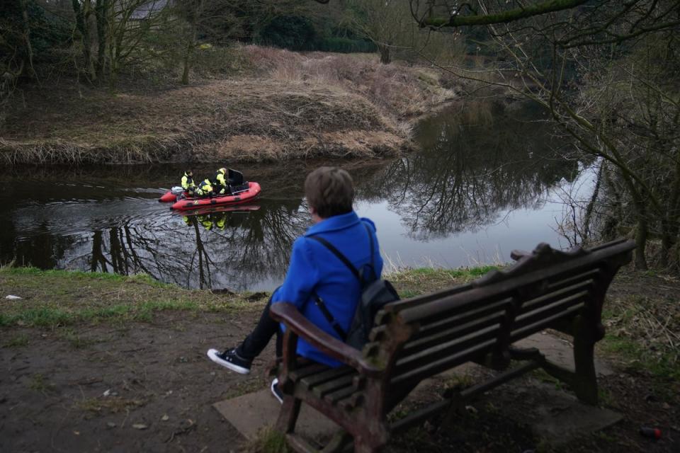 A woman sits on the bench where Nicola Bulley’s belongings were found (PA)