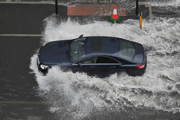 A car drives through deep water on a flooded road in Nine Elms, London on July 25 during heavy rain (Photo: JUSTIN TALLIS via Getty Images)