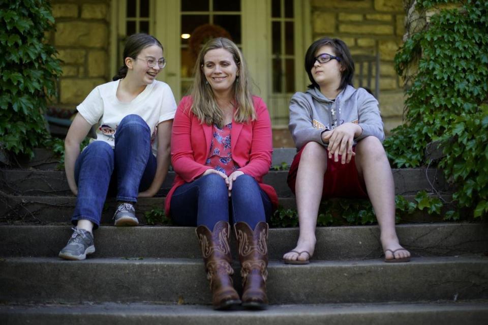 Heather Ousley sits with two of her children, Elliannah, 15, left, and Samuel, 13, in front of their Merriam home. She hopes to get them vaccinated against COVID-19 as soon as possible.