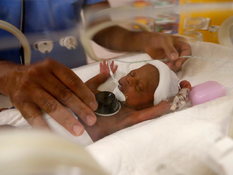 Paediatrician Dr. Msayif Khali examines with a stethoscope one of the nine babies protected in an incubator at the maternity unit of the Ain Borja clinic in Casablanca, Morocco, Thursday May 20, 2021, two weeks after Mali's Halima Cisse, 25, gave birth to nine healthy babies