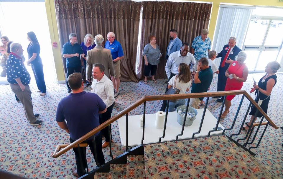 Candidates mingle with voters before the start of a forum at the Fort Walton Beach Auditorium on Thursday. The session featured candidates for Okaloosa County School Board and County Commission District 2 seats.