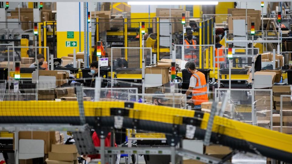 Mitarbeiter mit Mund-Nasen-Bedeckung in einem Logistikzentrum des Versandhändlers Amazon in Mönchengladbach.