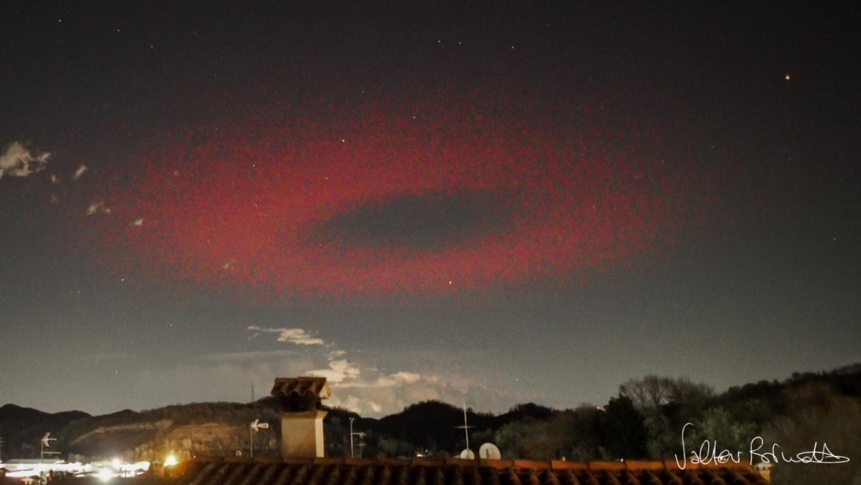  A red ring of light appears to hang above an Italian town. 