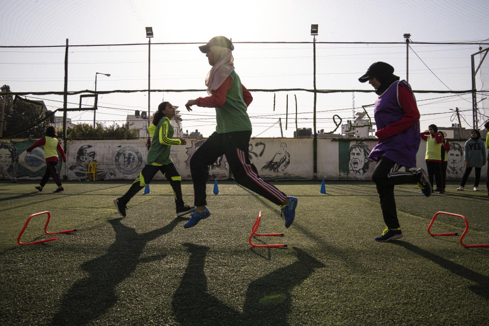 Palestinian girls run during a soccer training session at the Beit Hanoun Al-Ahli Youth Club's ground in the northern Gaza strip, Tuesday, Oct. 29, 2022. Women's soccer has been long been neglected in the Middle East, a region that is mad for the men's game and hosts the World Cup for the first time this month in Qatar. (AP Photo/Fatima Shbair)