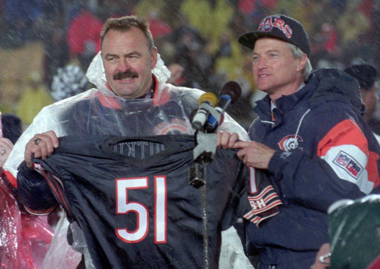 Former Chicago Bears linebacker Dick Butkus holds up his jersey after the team retired his number during on Oct. 31, 1994, at Soldier Field. At right is team president Mike McCaskey. 