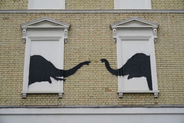 A new artwork depicting two elephants poking their heads out of blocked out windows