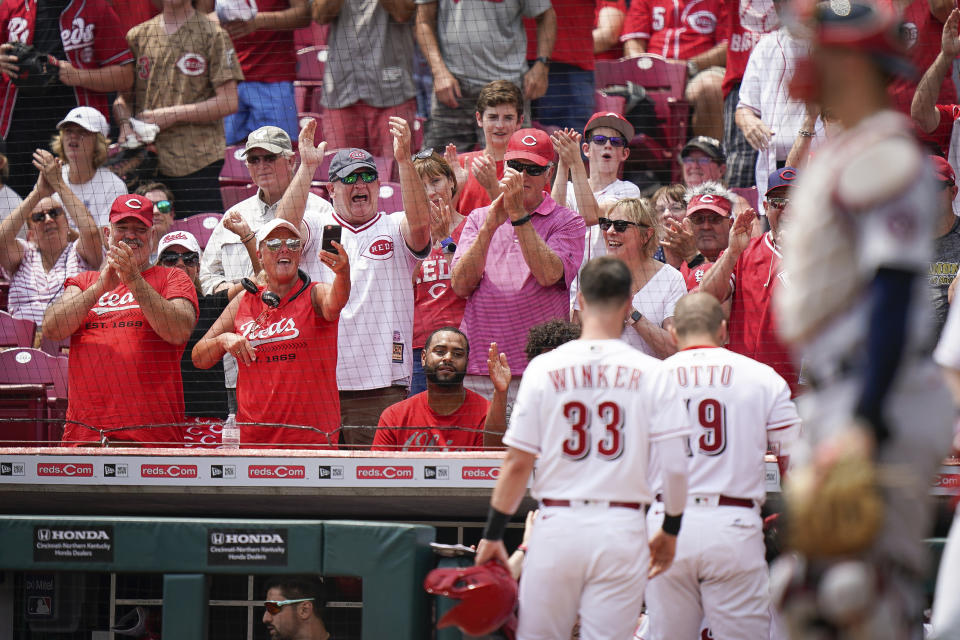 Fans celebrate after Cincinnati Reds' Joey Votto (19) hit a three run home run during the first inning of a baseball game against the St. Louis Cardinals in Cincinnati, Sunday, July 25, 2021. (AP Photo/Bryan Woolston)