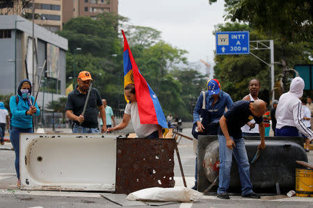Opposition supporters bang a metal barricade during a rally against Venezuela's President Nicolas Maduro in Caracas, Venezuela April 24, 2017. REUTERS/Carlos Garcia Rawlins