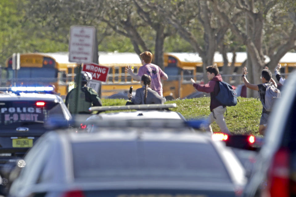 <p>Students run with their hands in the air following a shooting at Marjory Stoneman Douglas High School in Parkland, Fla., on Feb. 14, 2018. (Photo: John McCall/South Florida Sun-Sentinel via AP) </p>