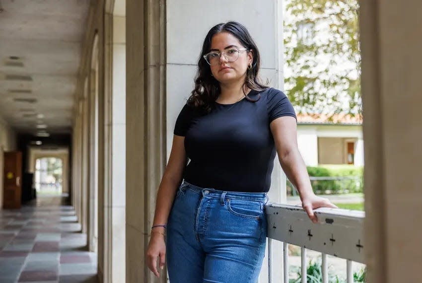 Priscilla Lugo, an alumna of the University of Texas at Austin, stands at a campus building in Austin on Monday. As student loan repayments resume, Lugo is bracing for the financial adjustments she’ll have to make.