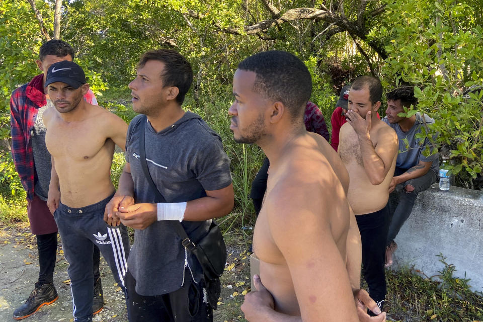 CORRECTS YEAR TO 2023 NOT 2022 - A group of Cuban men stand on the side of Garden Cove Road in Key Largo, Fla., Tuesday, Jan. 3, 2023. They said they arrived in the Keys on a migrant boat the day before. (David Goodhue/Miami Herald via AP)