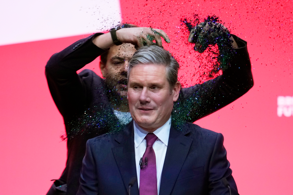 All that glitters: An activist storms the Liverpool stage last week and showers Starmer with sparkles (Getty Images)