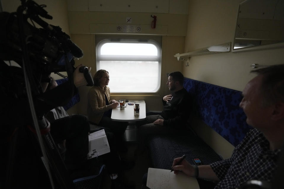 Ukrainian President Volodymyr Zelenskyy speaks during an interview with Julie Pace, senior vice president and executive editor of The Associated Press, as James Jordan, news director Europe and Africa, right, observes, on a train traveling from the Sumy region to Kyiv, Ukraine, Tuesday March 28, 2023. A team of journalists from The Associated Press traveled with Zelenskyy aboard his train for two nights as he visited troops along the front lines and communities that have been liberated from Russian control. Zelenskyy is hoping his trips keep the public's attention on the war, particularly in parts of Ukraine where life can often appear to have returned to normal. (AP Photo/Efrem Lukatsky)