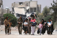 <p>Syria Democratic Forces (SDF) fighters walk with people that fled their homes due to clashes between Islamic State fighters and Syria Democratic Forces (SDF) towards safer parts of Manbij, in Aleppo Governorate, Syria, Aug. 7, 2016. (REUTERS/Rodi Said) </p>