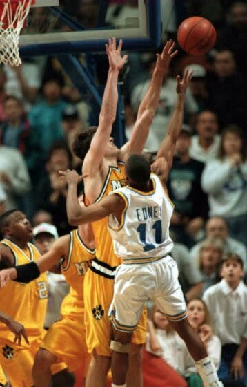 UCLA's Tyus Edney lofts a shot over Missouri's Derek Grimm at the buzzer for a 75-74 victory.