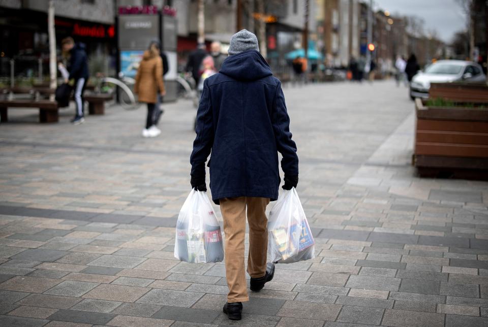 A shopper carries his purchases, including bottles of fizzy drink including Coca Cola, in Walthamstow, east London on February 13, 2022. - UK annual inflation struck 5.4 percent in December, stoking fears of a cost-of-living squeeze as wages fail to keep pace. (Photo by Tolga Akmen / AFP) (Photo by TOLGA AKMEN/AFP via Getty Images)