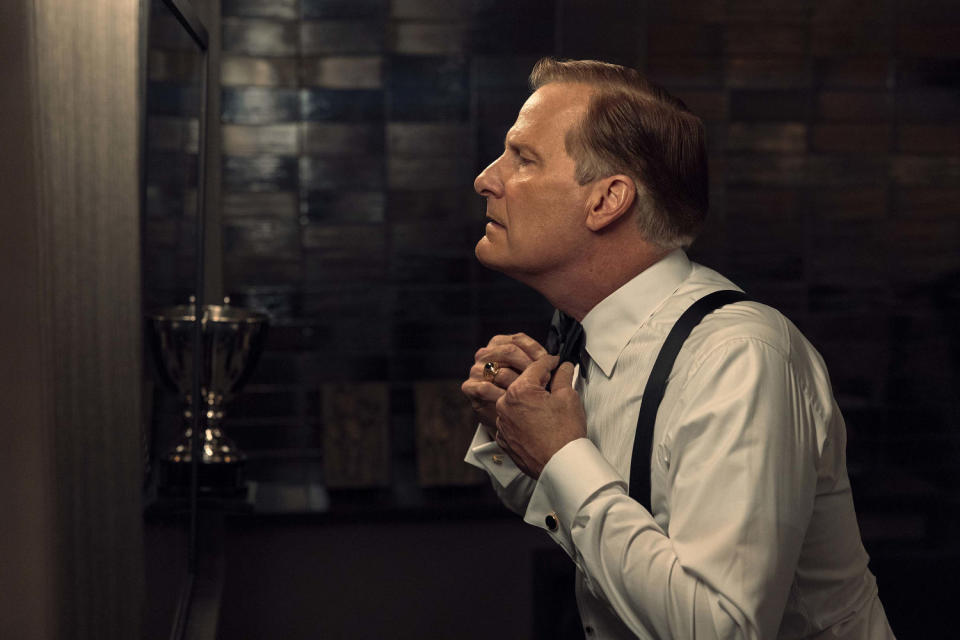 Jeff Daniels playing Charlie Croker and tying his tie. (Mark Hill / Netflix)