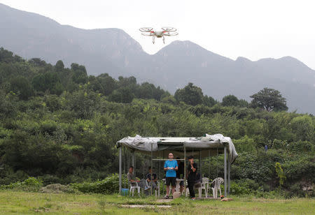 A DJI drone flies by a trainee at LTFY drone training school on the outskirts of Beijing, China July 27, 2017. Picture taken July 27, 2017. REUTERS/Jason Lee