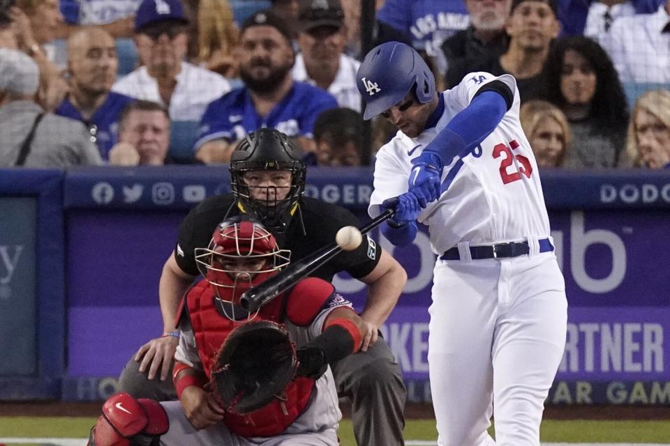Los Angeles Dodgers' Trayce Thompson, right, hits a solo home run in front of Washington Nationals catcher Keibert Ruiz
