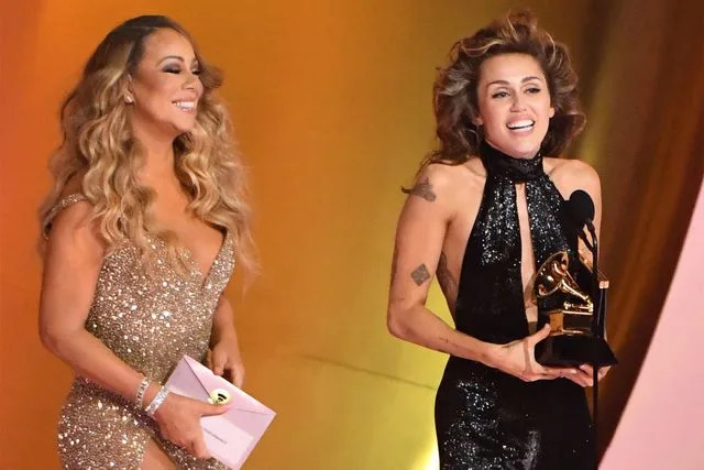 <p>JC Olivera/WireImage</p> Mariah Carey and Miley Cyrus at the 2024 Grammys.