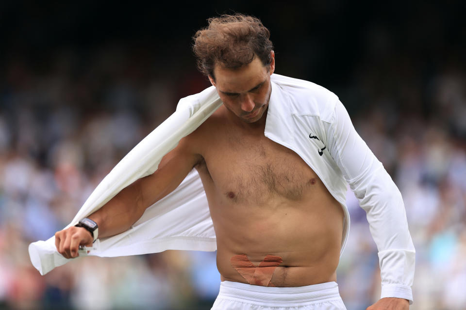 Rafael Nadal se quita la camisa y revela la cinta de su lesión abdominal después de su victoria en cinco sets durante el día diez del Campeonato de Wimbledon 2022. (Foto: Simon Stacpoole/Offside/Offside a través de Getty Images)