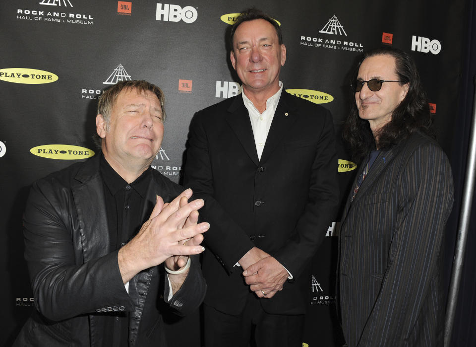 FILE - This April 18, 2013 file photo shows, from left, Alex Lifeson, Neil Peart, and Geddy Lee of Rush at the Rock and Roll Hall of Fame Induction Ceremony in Los Angeles. Peart, the renowned drummer and lyricist from the band Rush, has died. His rep Elliot Mintz said in a statement Friday that he died at his home Tuesday, Jan. 7, 2020 in Santa Monica, Calif. He was 67. (Photo by Jordan Strauss/Invision, File)