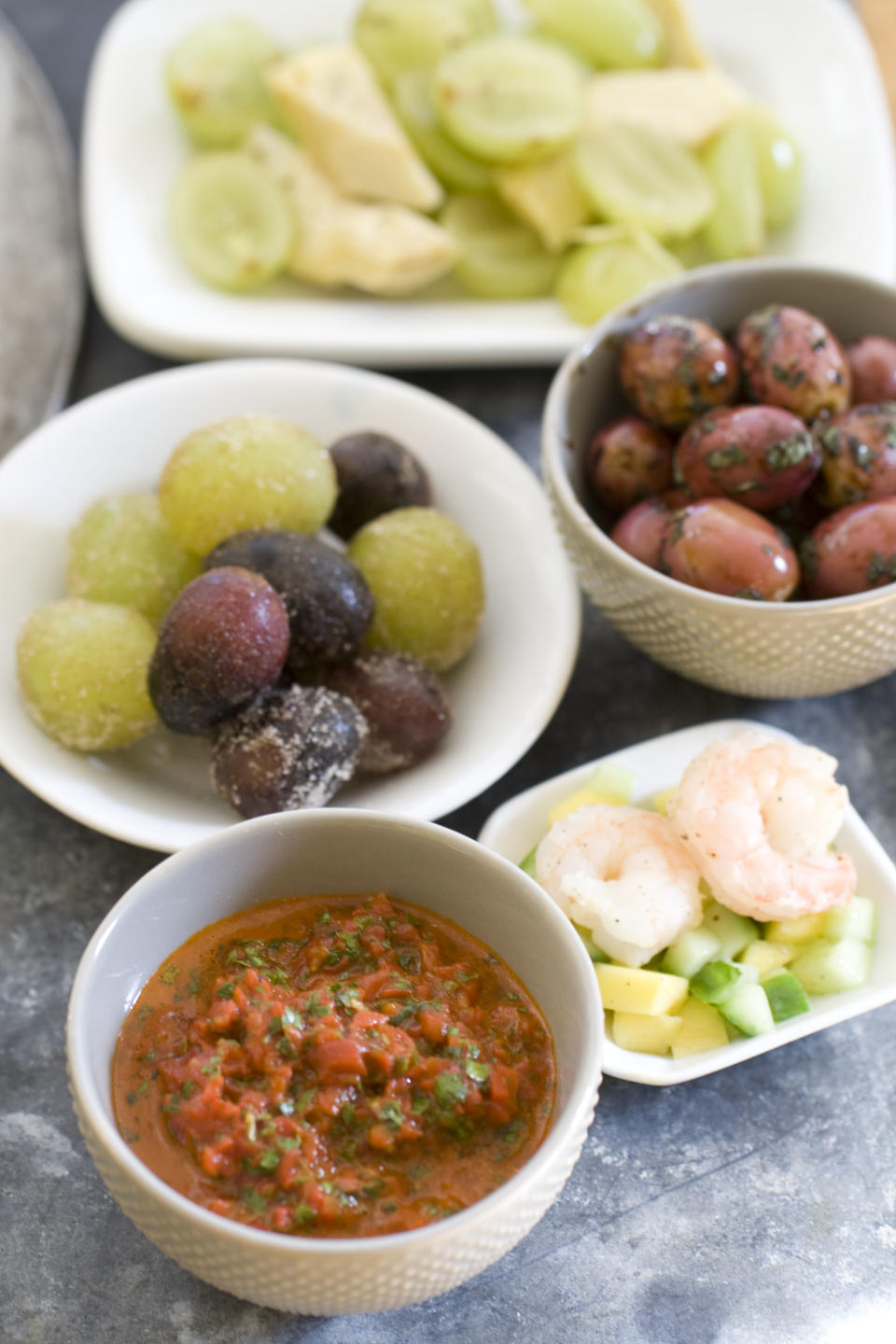 This Nov. 4, 2013 photo shows grapes tossed with artichoke hearts, marinated olives, shrimp tossed with mango and cucumber, roasted red pepper chimichuri pesto, and sugared grapes in Concord, N.H. (AP Photo/Matthew Mead)