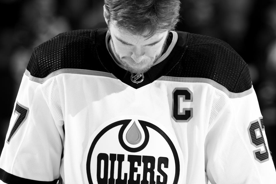 NEW YORK, NY - JANUARY 03:  (EDITORS NOTE: Image has been converted to black and white.) Connor McDavid #97 of the Edmonton Oilers looks on during the National anthem prior to the game against the New York Rangers at Madison Square Garden on January 3, 2022 in New York City. (Photo by Jared Silber/NHLI via Getty Images)