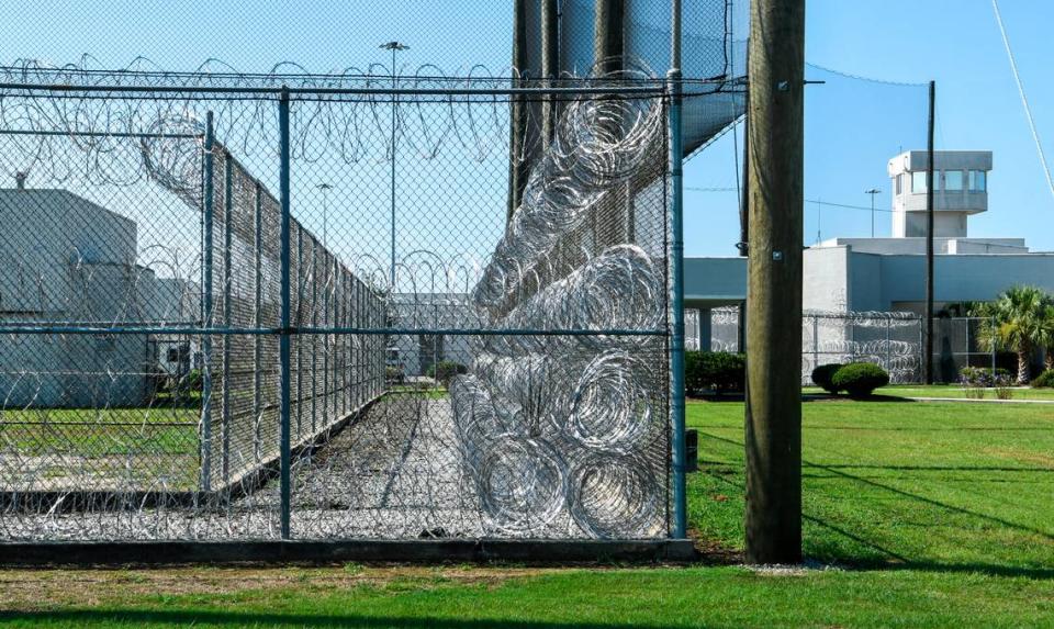Coiled rolls of barbed wire sit between double fences as the guard tour looms in the background near the front entrance to the S.C. Department of Corrections Ridgeland Correctional Institution.