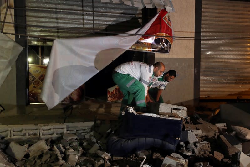 Medics inspect the damage to the home of Palestinian Islamic Jihad field commander Baha Abu Al-Atta after it was hit by an Israeli strike that killed him in Gaza City