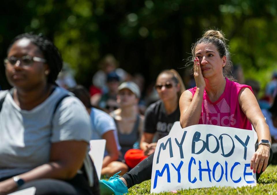 Maria Laura Alfonsin, from Aventura, wipes a tear as she listens to speakers at the “Bans Off Our Bodies” rally at Ives Estates Park in Miami, Florida on Saturday, May 14, 2022. The rally was held in opposition of the leaked draft opinion from SCOTUS which aims to overturn Roe v. Wade, removing women’s constitutional right to an abortion.