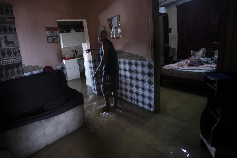 Carlos de Souza, 86, shows the inside of his flooded house after deadly, heavy rainfall in Duque de Caxias, Brazil, Sunday, Jan. 14, 2024. (AP Photo/Bruna Prado)