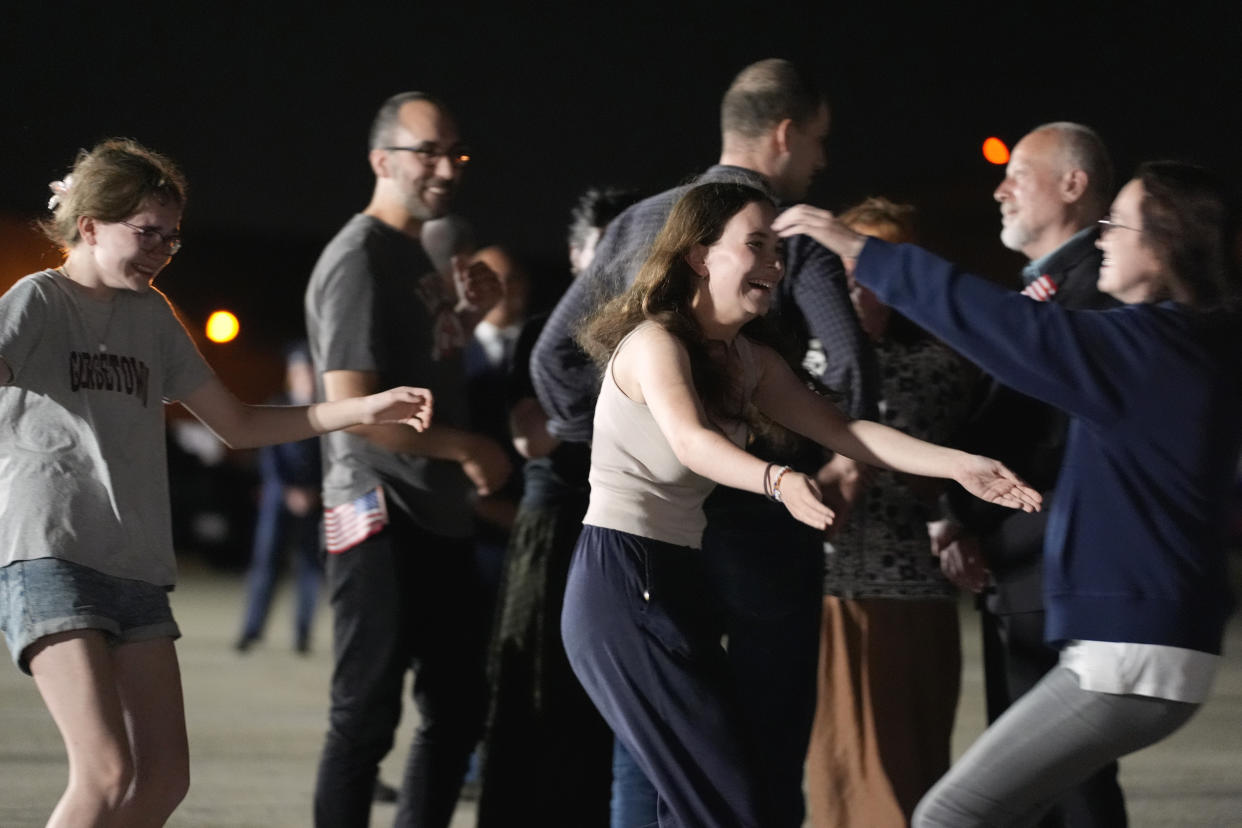 Miriam Butorin and Bibi Butorin, daughters of Alsu Kurmasheva, run to hug their mother at Andrews Air Force Base.