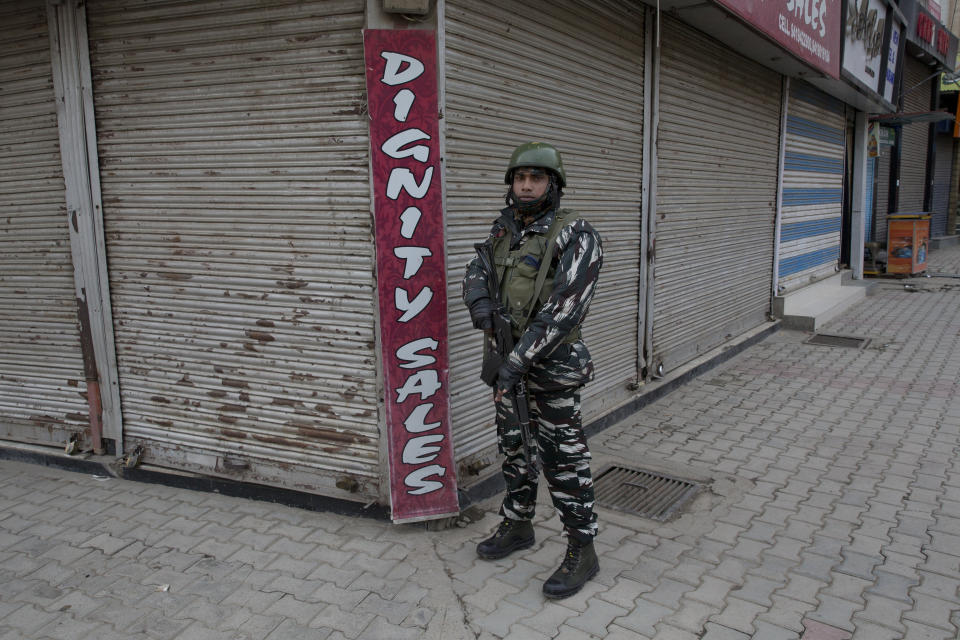 An Indian paramilitary soldier stands guard next to closed shops in Srinagar, Indian controlled Kashmir, Saturday, Feb. 23, 2019. Police have arrested at least 200 activists seeking the end of Indian rule in disputed Kashmir, officials said Saturday, escalating fears among already wary residents that a sweeping crackdown could touch off renewed anti-India protests and clashes. (AP Photo/ Dar Yasin)