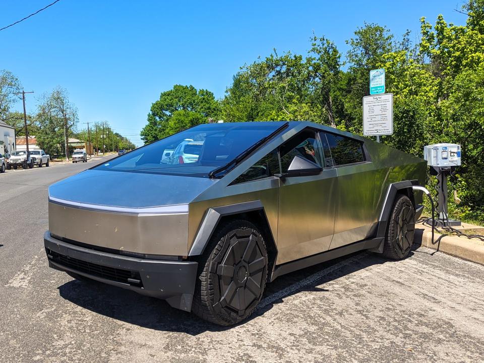 Tesla Cybertruck parked and charging on a sunny day