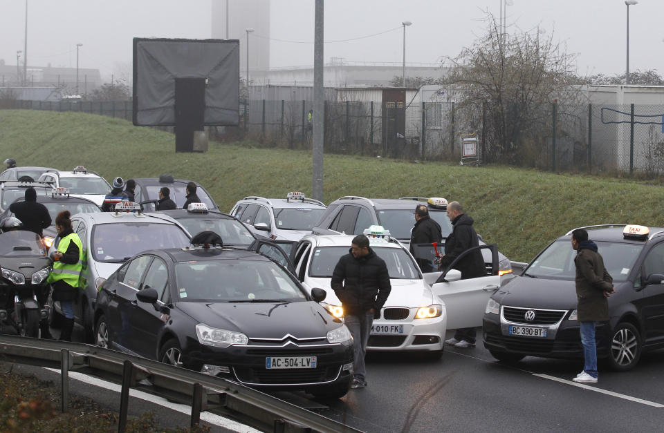 Taxi drivers stop the traffic on the highway leading to Paris, Thursday, Jan. 10, 2013 at Roissy airport. Taxi drivers across France were putting on the brakes to clog traffic, slow access to airports and force would-be passengers to find alternate transport in a strike over government efforts to deregulate the transportation industry. (AP Photo/Remy de la Mauviniere)