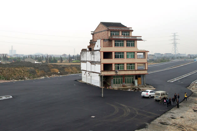 #6 Chinese Highway House<br> A five-storey house, which was marooned in the middle of a new road in China for more than a year because its owner Luo Baogen refused to leave. Luo, 67, said he had just finished the home at a cost of $95,000 and had been offered only $35,000 to move. Finally he signed the agreement to demolish the house after discussions with the local government and his relatives.