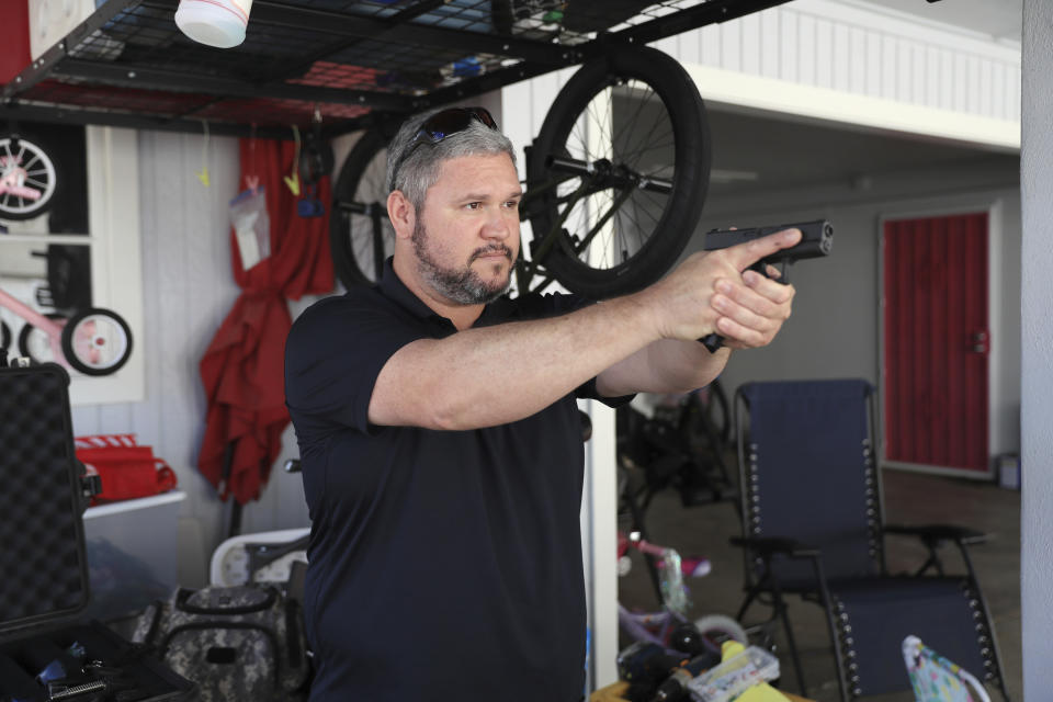 Kainoa Kaku, president of the Hawaii Rifle Association, aims his handgun after drawing it from a concealed carry position, Thursday, June, 23, 2022 in Honolulu. (AP Photo/Marco Garcia)